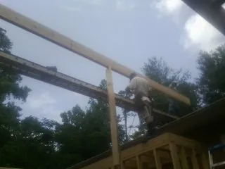 Carpenter setting a ridge beam over a new addition frame — Ice Dam Removal by Roofing Brothers in Dodge Center