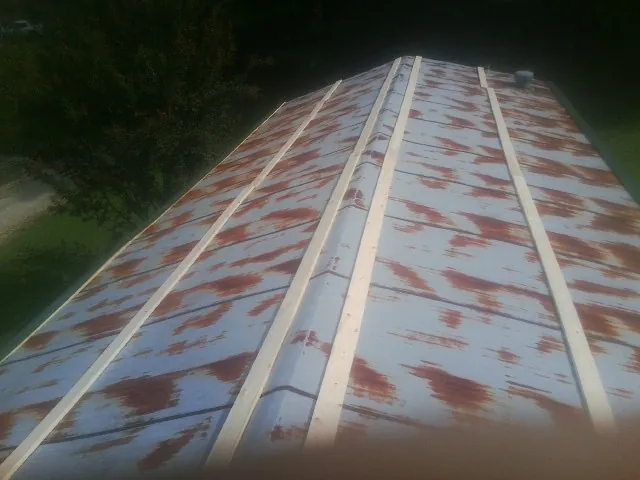 Rusted metal roof panels with new wood purlins before replacement — Storm Damage Roof Repair in Dodge Center by Roofing Brothers