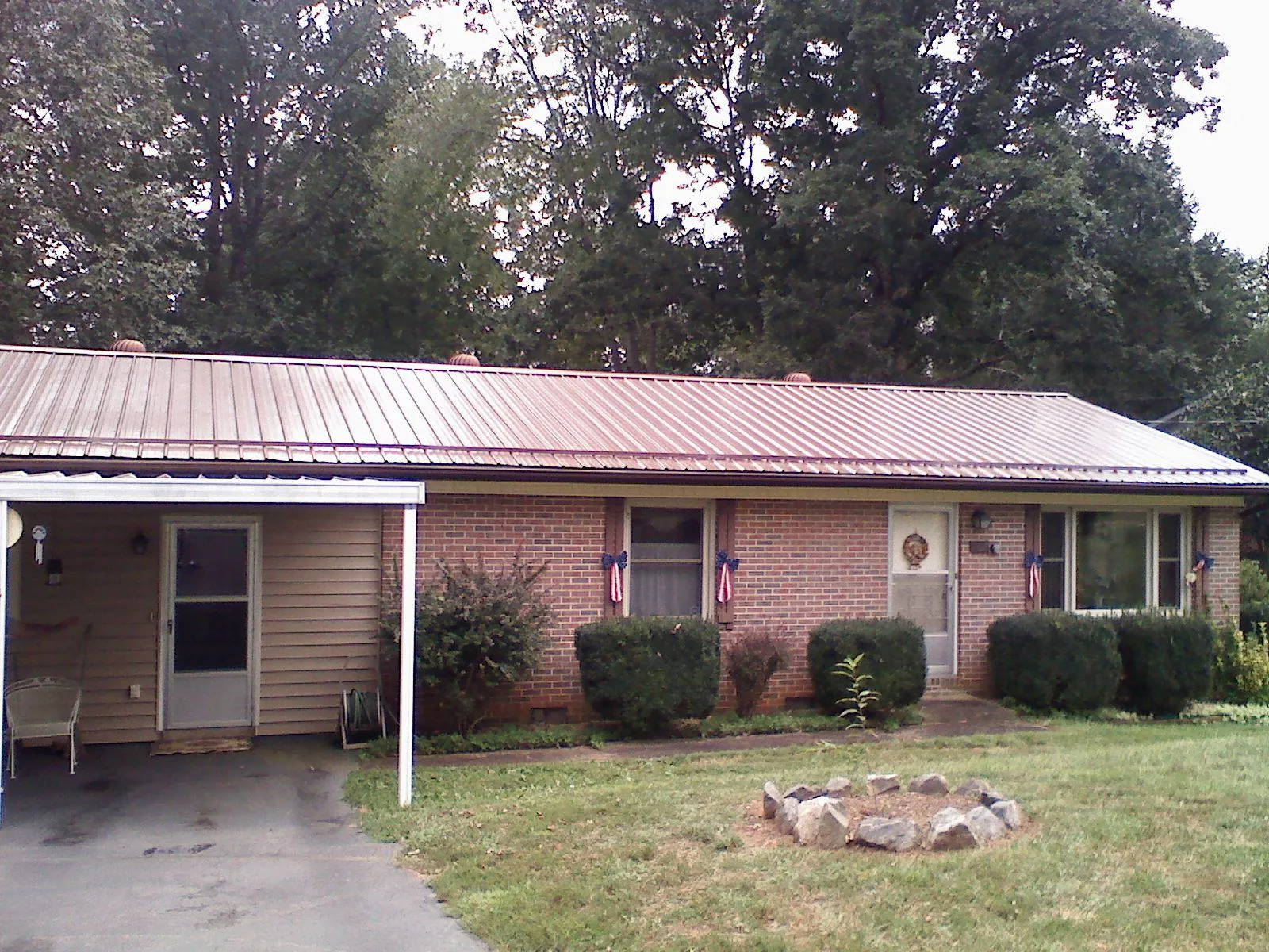 Bronze metal roof and carport on a brick ranch home — Roof Repair work by our crew in Dodge Center